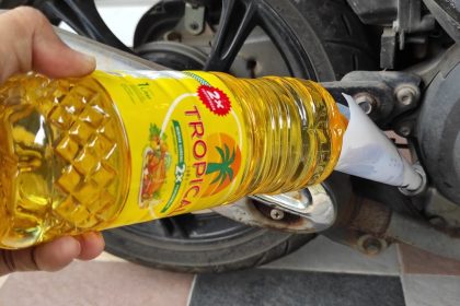 Ilustrasi botol minyak goreng dan bahaya endapan lumpur pada mesin motor